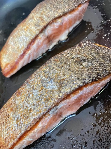 regal marlborough king salmon fresh fillets cooking in a frying pay, skin side up